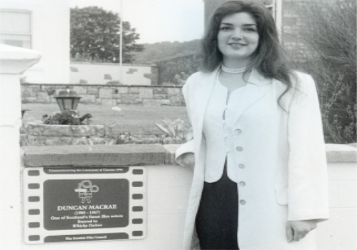 Christine Caldwell, grand-daughter of Duncan Macrae, unveiling a plaque to him at Dundonald Villa, his second home in Millport in 1996.