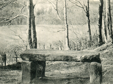 The gravestone on its four stone pillars.